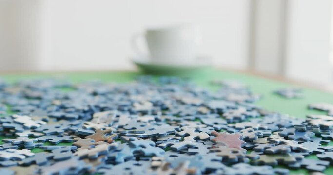 Video of puzzles and cups of coffee on green table