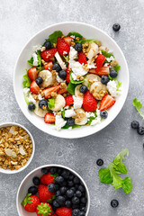 Fruit and berry salad with fresh strawberry, blueberry, banana, cottage cheese and granola with almond. Healthy food, diet breakfast