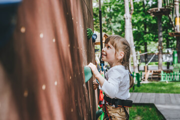 Little girl preschooler climbing on the stand