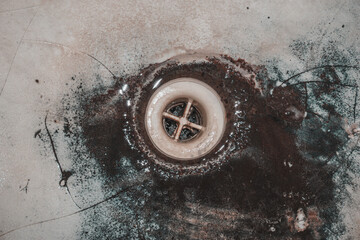 Very old dirty sink with plastic drain, old plumbing.