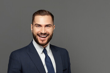 Portrait of successful businessman on grey studio wall background