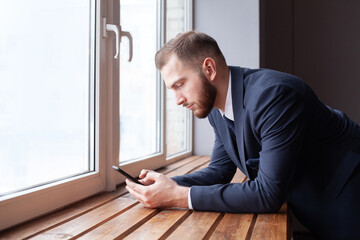 Businessman using mobile phone app texting with clients