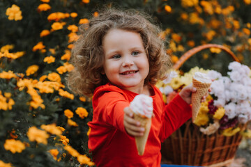 cute curly little girl eating ice cream in park fall time, autumn, card, flowers, banner