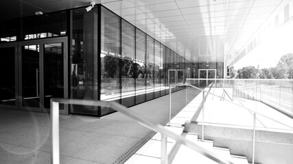 Abstract fragment of contemporary architecture, walls made of glass and concrete.Office building. Bright sunny day with sunbeams. Black and white.