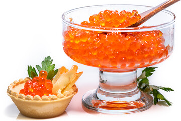 Red caviar in tartlet with oil and green herbs. Delicious and expensive caviar in glass cup with...