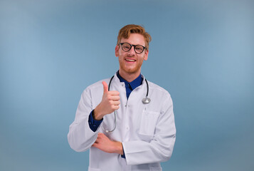 young doctor with a smile showing thumbs up, approving gesture with a smile on a blue background