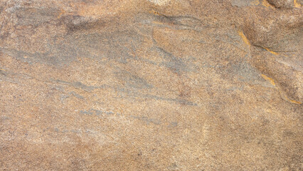 Stone textured background of sand color with natural spots patterns and scratches. Old stone wall is sand colored with dark patterns.