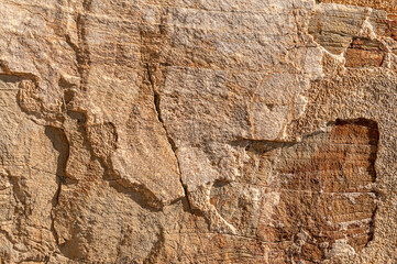 Stone wall is sand colored with light and dark spots everywhere. Stone textured background is sand-colored.