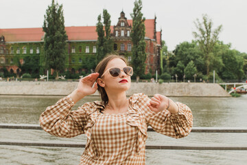 Girl in sunglasses on the background of the embankment