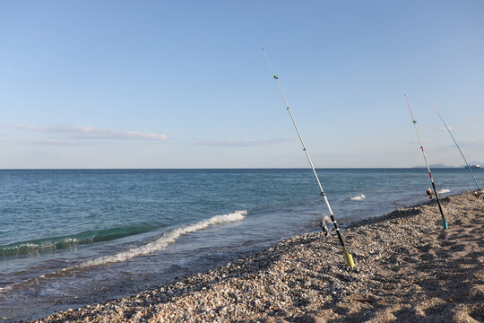 Fishing rods on sandy beach along sea
