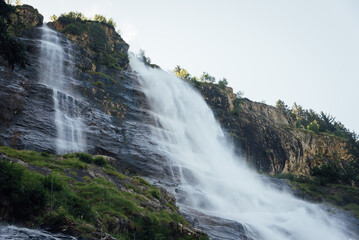 Fototapeta premium La cascade de la Fare à Vaujany. Une cascade de montagne. Une cascade dans les Alpes. Une chute d'eau avec des falaises.