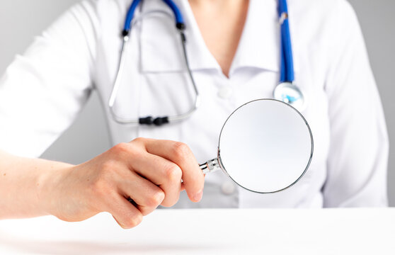 Magnifying lens in doctor hand. Abstract checkup concept. High quality photo