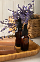 Essential oil and handmade soap on a white wood background. Spa concept. Handmade soap, essential oil and lavender flowers.Copy space.Place for text