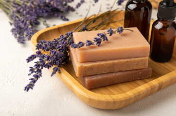 Lavender spa products and lavender flowers on white texture wood.SPA concept. Handmade soap on a bamboo stand, with lavender scent.Cosmetic treatment.Copy space.Place for text.Flat lay.