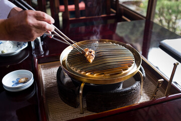 chef in japanese restaurant prepares grill to cook by rubbing with fat