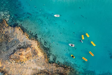 Gordijnen Aerial drone photograph watersport boat at fig tree bay beach cyprus © Michalis Palis