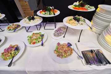 buffet with appetizers, salads in plates at the banquet