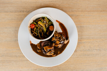 Filet Mignon steaks with a mushroom sauce and a bowl of colorful vegetables