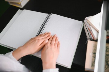 Blind woman read book written in Braille