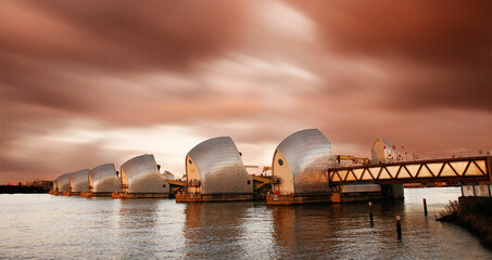 London River Thames Flood Barrier over dramatic cloudy sky.