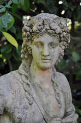 Weathered goddes statue in the garden