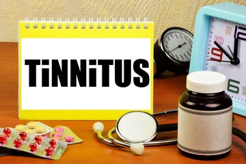 Tinnitus is a symptom of hearing aid disorders. An inscription on the background of medicines, a...
