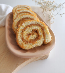 swiss roll, roll cake over wooden table