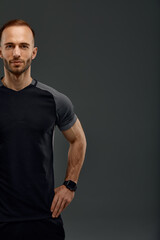 Fototapeta na wymiar Croped portrait of male fitness model in black top. Sport banner. Grey background with space for text, Copy space.