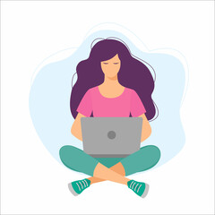 Young girl sitting on the floor on the carpet with a laptop. Woman sitting cross-legged and working on laptop.