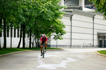 Caucasian handsome young man in protective helmet goes out for bicycle ride through city streets on blurred background. Cyclist male ride bike outdoors in urban.
