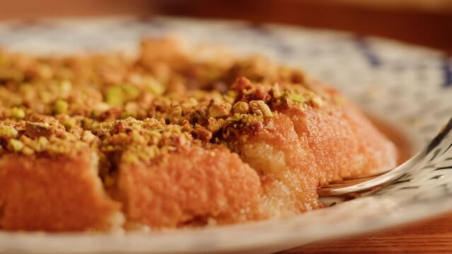 Arabic traditional sweets, kunafa dish close-up. Middle eastern national food desserts. Muslim family dinner, Ramadan, iftar. Arabian cuisine delivery.