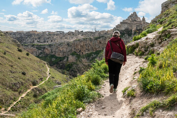 A woman hiking through the canyon of Matera, Italy