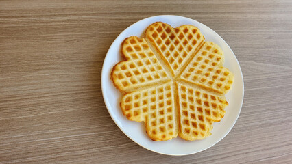 Homemade Belgian waffles in the shape of a heart on the table.