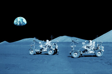 Two astronauts are riding lunar rovers on the moon. Elements of this image furnished by NASA - obrazy, fototapety, plakaty