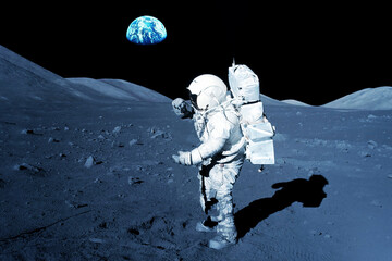 Astronaut on the moon, with the Earth in the background. Elements of this image furnished by NASA
