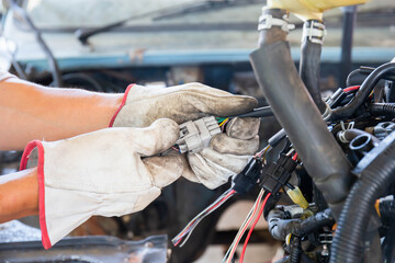 Auto mechanic doing car service and maintenance. Car wiring with adapters and connectors changing