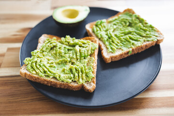 healthy plant-based food, basic plant-based smashed avocado toast with half avocado next to it