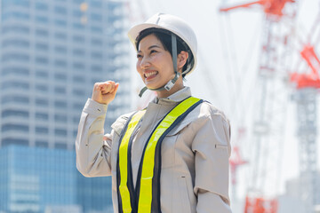 ガッツポーズをする工事現場で働く女性