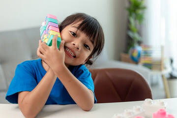 Adorable little girl playing toy blocks in a bright room