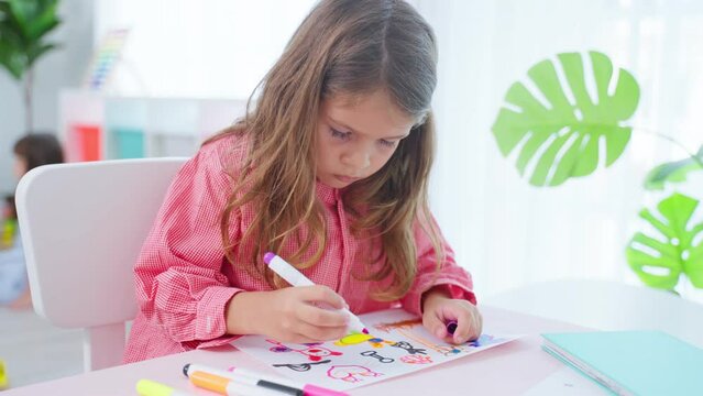 Caucasian young girl student drawing art picture on paper at school