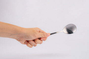 Woman hand holding a silver spoon on white background.