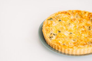 Open box with chicken pie stands on a white table.