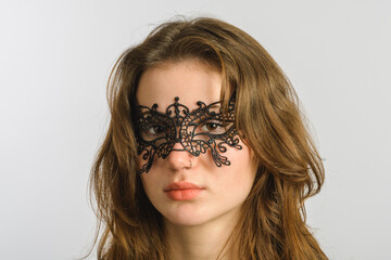 Long hair pretty young woman in openwork lace eye mask with noze ring. Sexy masquerade concept...