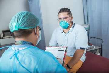 An emergency physicians explains in detail the diagnosis to a male patient in his 30s, who is...