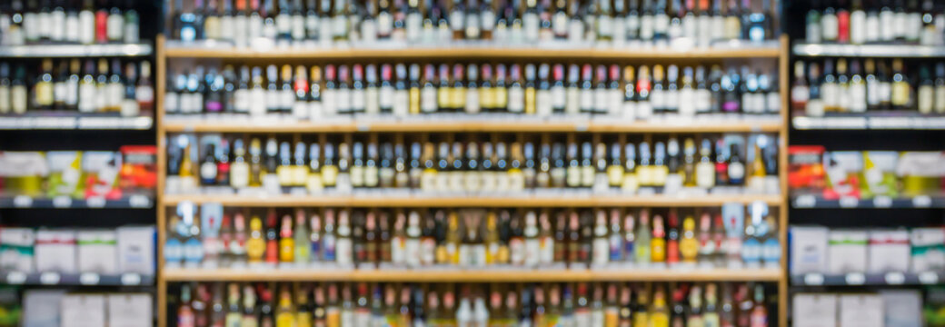 Abstract blur wine bottles on liquor alcohol shelves in supermarket store background