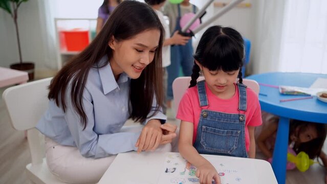 Back to school and summer course. Kindergarten teacher with children drawing and coloring.