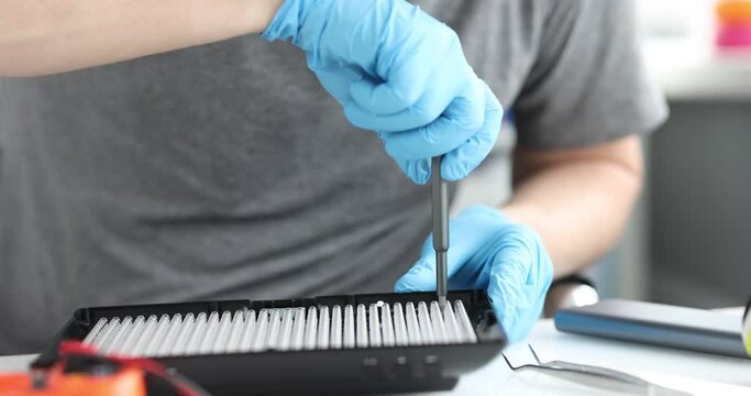 Male repairman repairing lighting equipment with oled lamps closeup