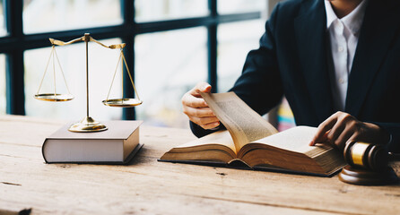 Close up lawyer businessman working or reading law book in office workplace for consultant lawyer...
