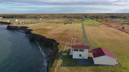 Aerial view over a residential property close to eroding coastal cliffs on the Acadian Peninsula in Caraquet, New Brunswick, Canada. With copy space.