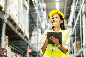 Portrait of smiling asian woman business using digital  tablet checking amount of stock product inventory on shelf at distribution warehouse factory, Logistics business planning concept